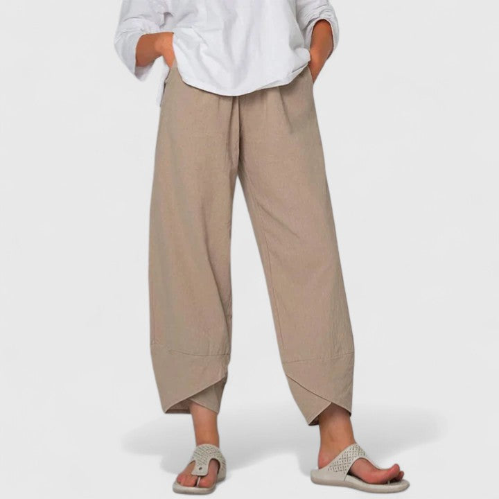 Poppy women's wide-leg trousers in a flowing beige fabric, featuring a relaxed fit and unique tulip hem.