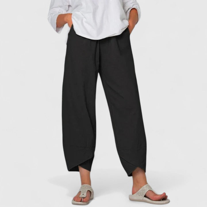 Poppy women's black wide-leg trousers with a relaxed fit, flowing drape, and handy pockets.