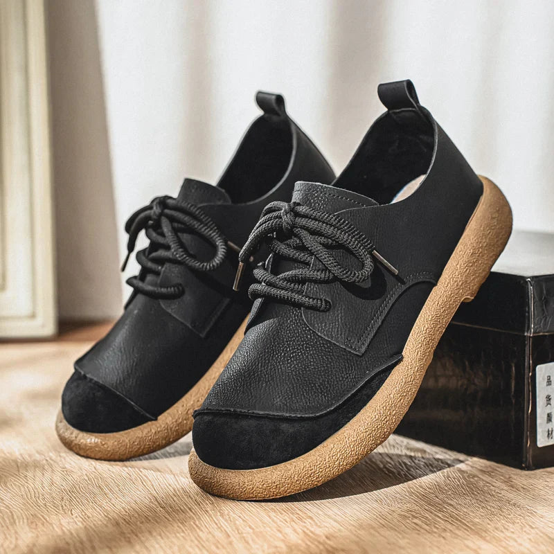 Men's black leather lace-up walking shoes with a textured tan cushioned sole and rounded toe design.
