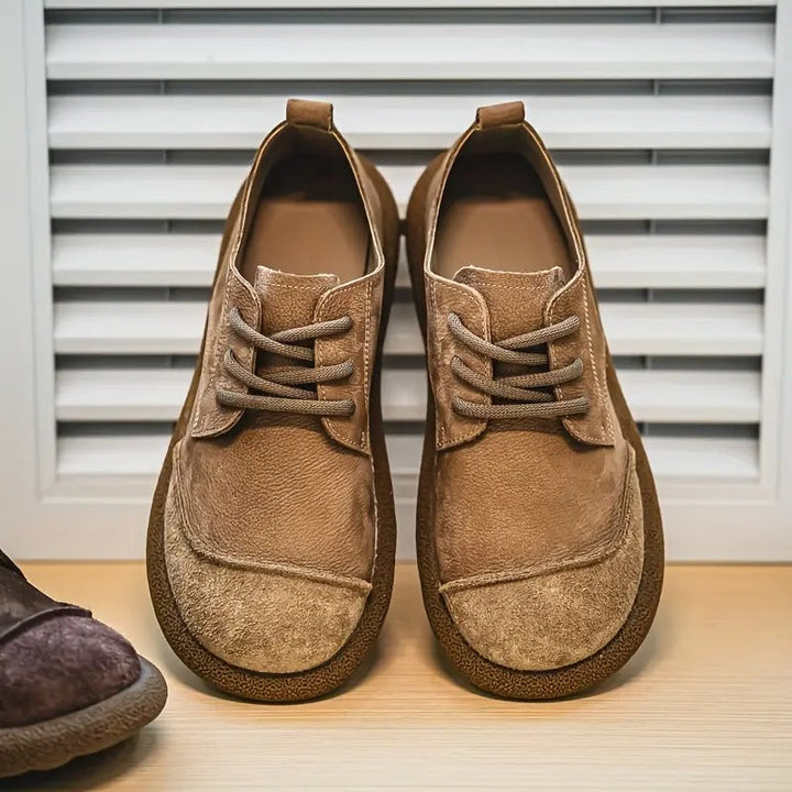 Tan leather lace-up walking shoes with a rounded toe, suede-textured front panel, and thick cushioned soles.