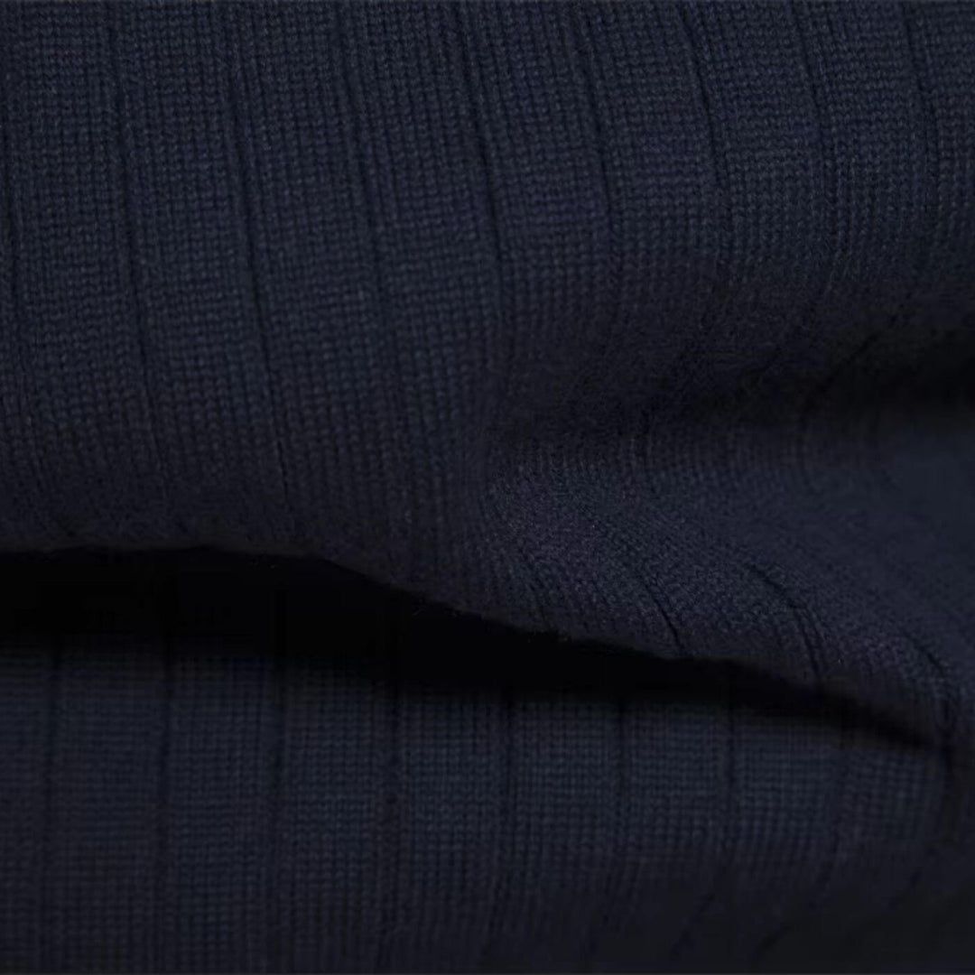 Close-up of a navy blue men's ribbed knit jumper, showcasing the soft, textured fabric and vertical knit pattern.