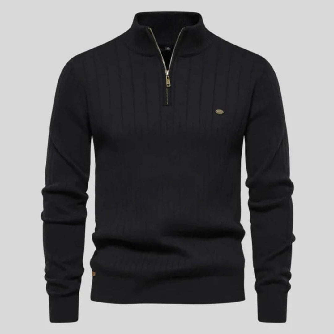 Black ribbed knit jumper with a half-zip collar, long sleeves, and a subtle metallic chest logo detail.