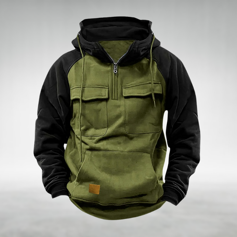 Olive green and black colour-block utility hoodie with a half-zip neckline, drawstring hood, and chest flap pockets.