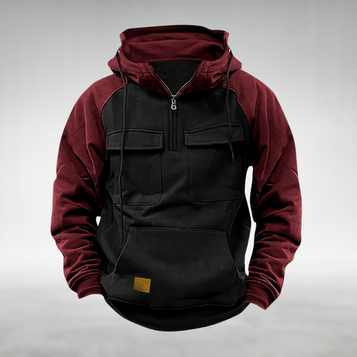 Men's burgundy and black colour-block half-zip hoodie with chest flap pockets, kangaroo pocket, and drawstring hood.
