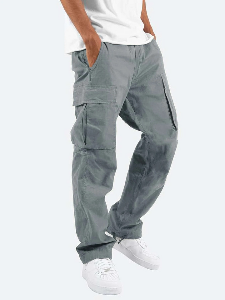 Grey relaxed-fit men's cargo trousers with utility side pockets and a straight-leg cut, styled with a white t-shirt.