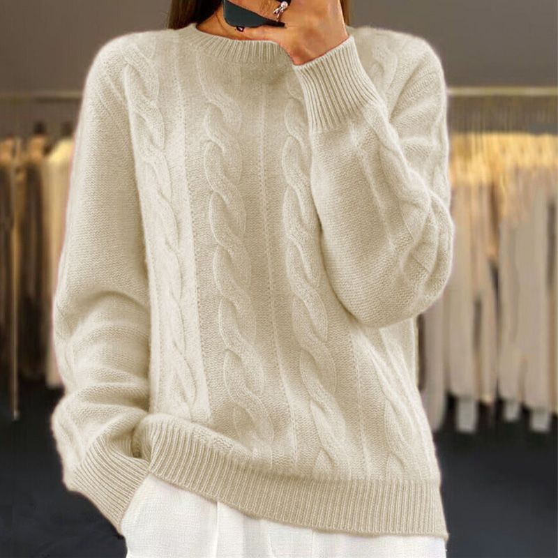 Cream cable knit crew neck jumper with a relaxed fit, ribbed cuffs, and hem, worn by a person in a store.