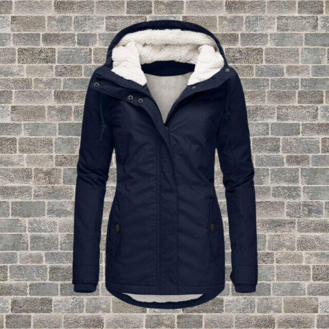 Navy blue Rosalind parka with a plush white fleece-lined hood, full zip front, and flattering mid-length silhouette.