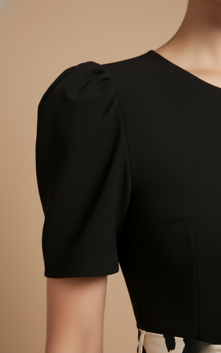 Close-up of a Rosalind black short sleeve tiered maxi dress, showcasing the clean bodice and gently puffed sleeve.