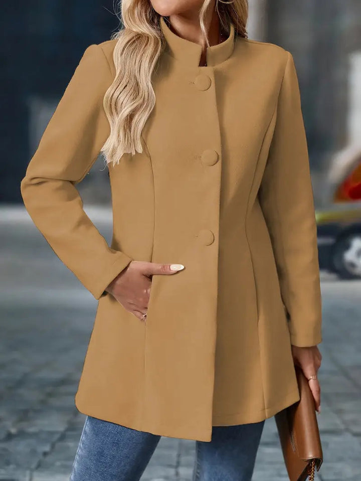 Camel-colored mid-length coat with a stand collar, covered button front, and tailored waist silhouette.