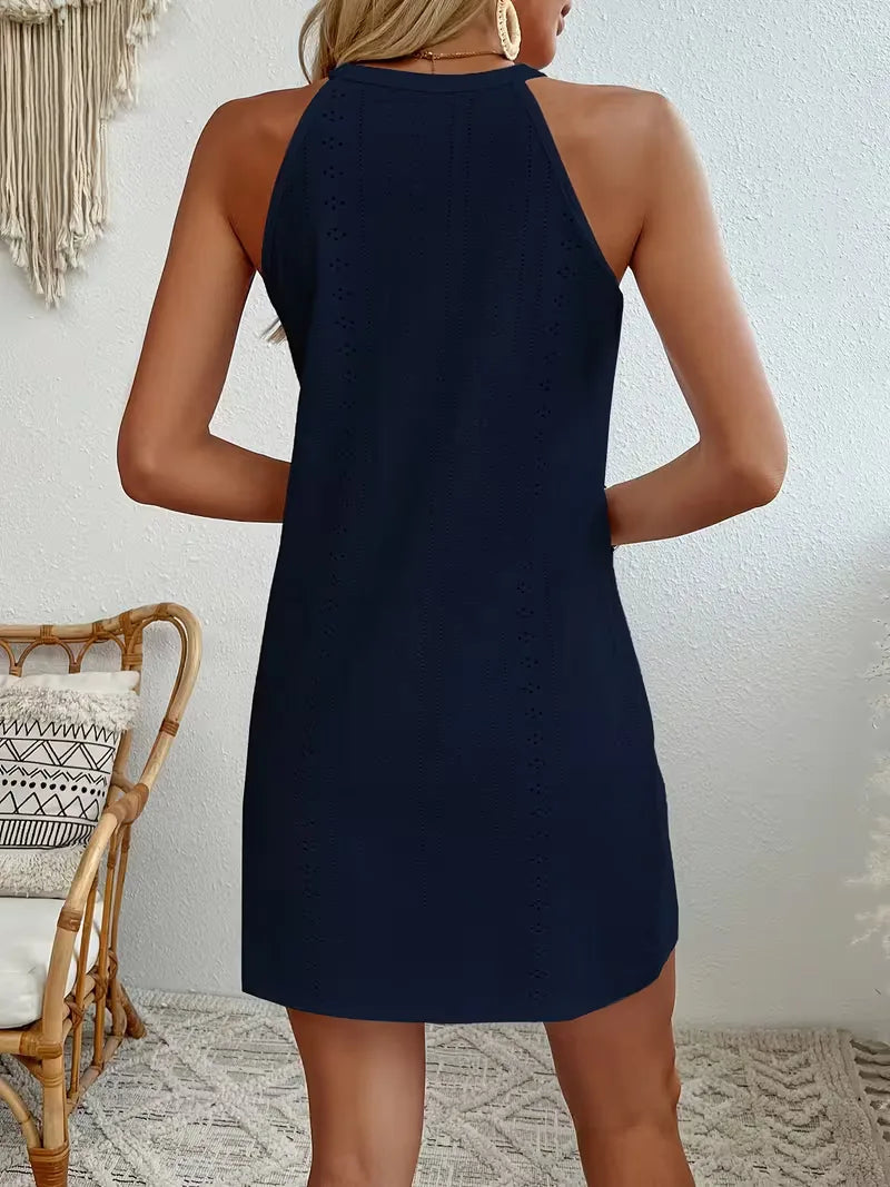 Navy blue eyelet halter mini dress with a relaxed A-line silhouette and delicate lace detailing.
