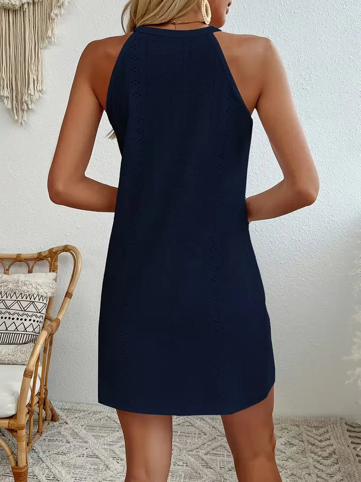 Navy blue eyelet halter mini dress with a relaxed A-line silhouette and delicate lace detailing.