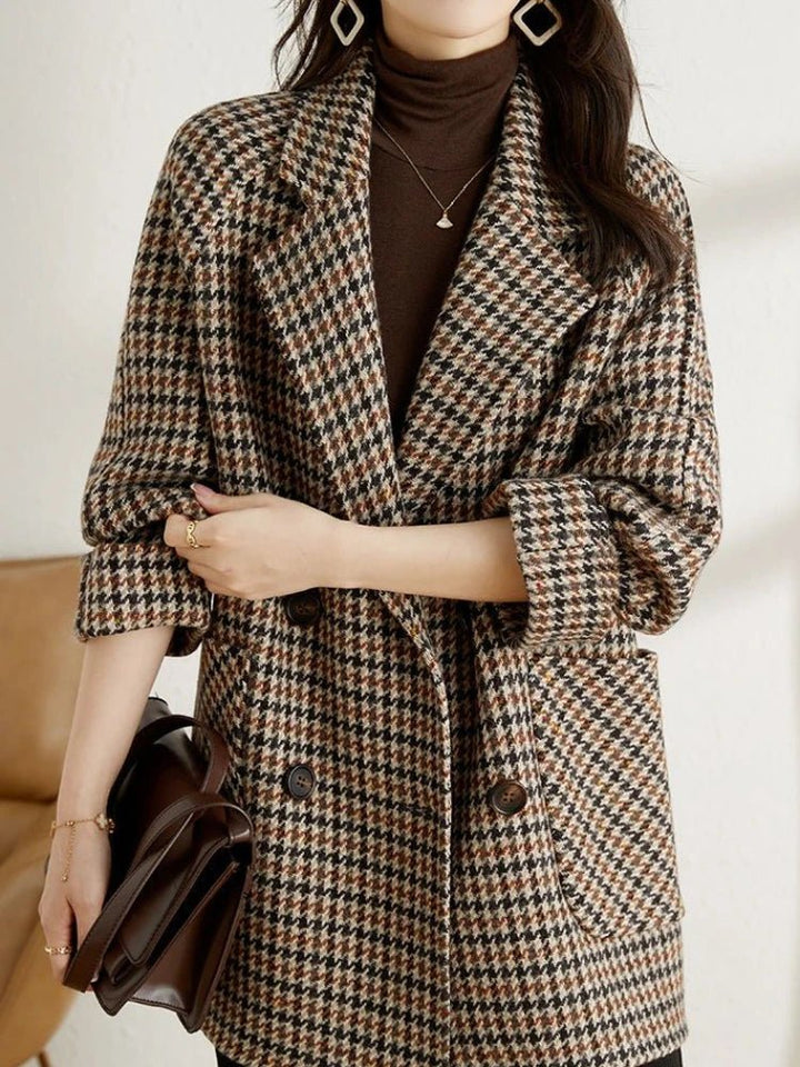 Women's brown and black houndstooth double-breasted blazer with a notched lapel and relaxed fit.