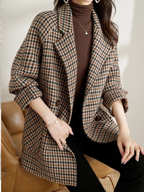 Brown and black houndstooth double-breasted blazer with notched lapels and a relaxed fit, worn over a brown turtleneck.