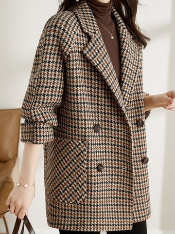 Women's brown and black houndstooth double-breasted blazer with notched lapels and side pockets.