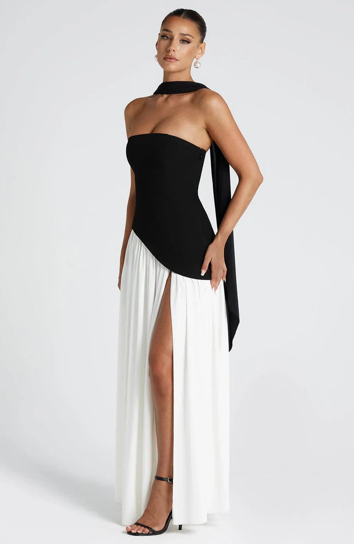Black and white strapless corset maxi dress with a high leg slit and draped scarf detail.