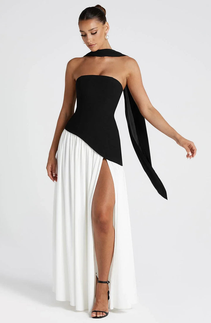Black and white strapless corset maxi dress with a high leg slit and draped scarf detail.