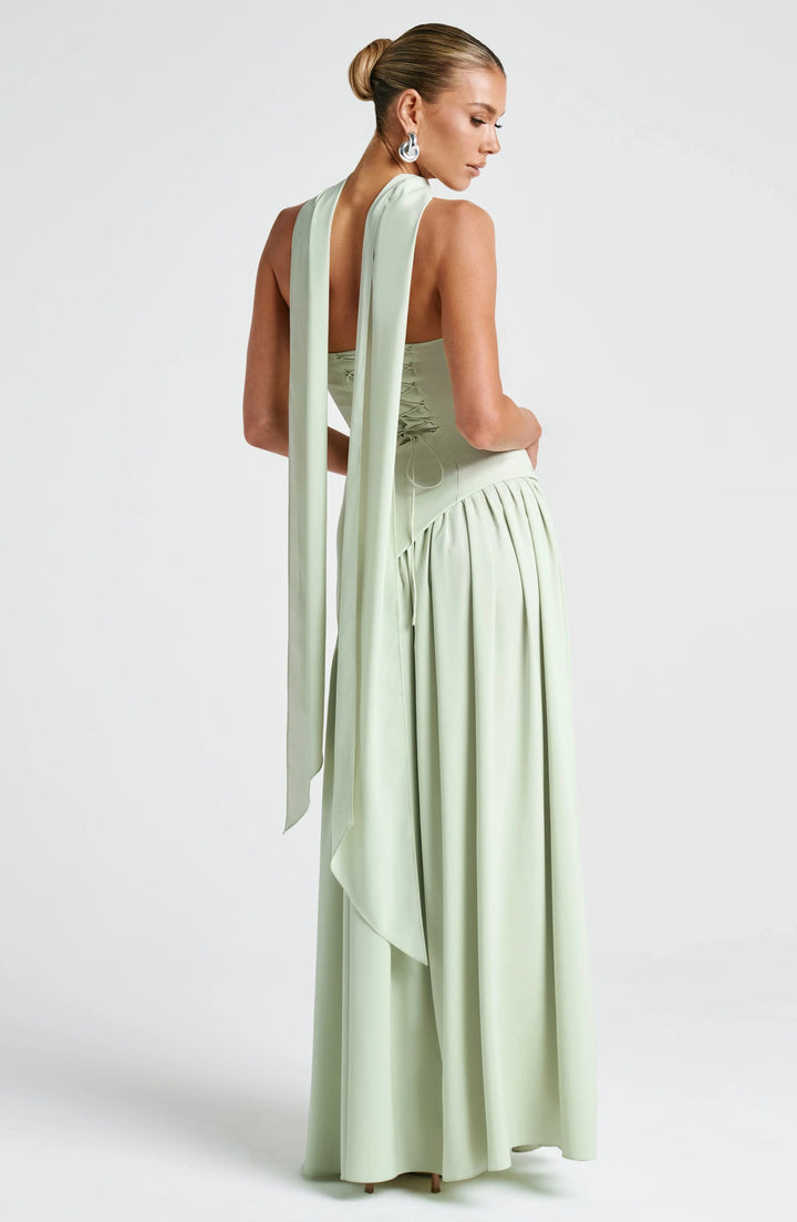 Sage green strapless corset maxi dress with lace-up back and elegant draped scarf panels.