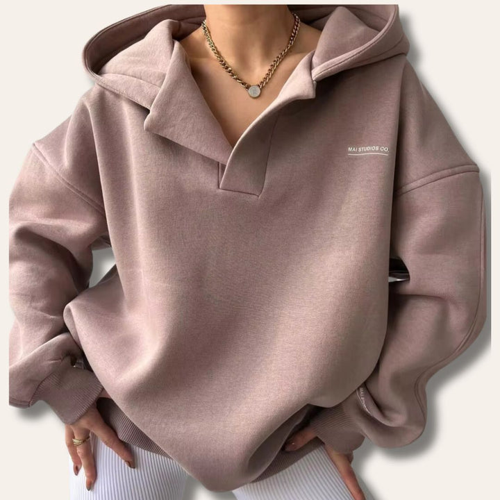 Oversized mauve V-neck pullover hoodie with drop shoulders, ribbed cuffs, and subtle chest branding.