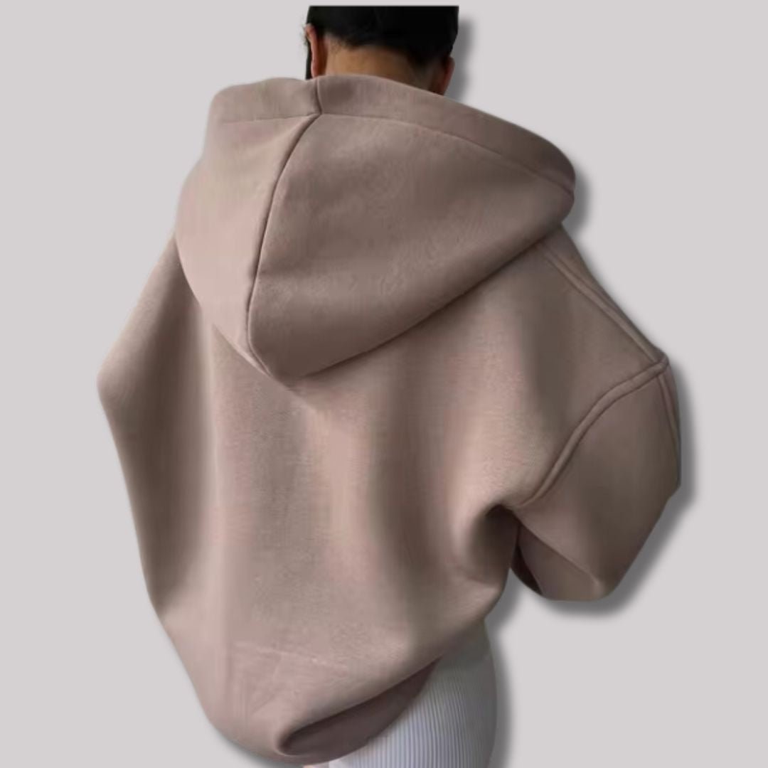 Back view of a dusty pink oversized hoodie with a drop-shoulder design and a large, structured hood.