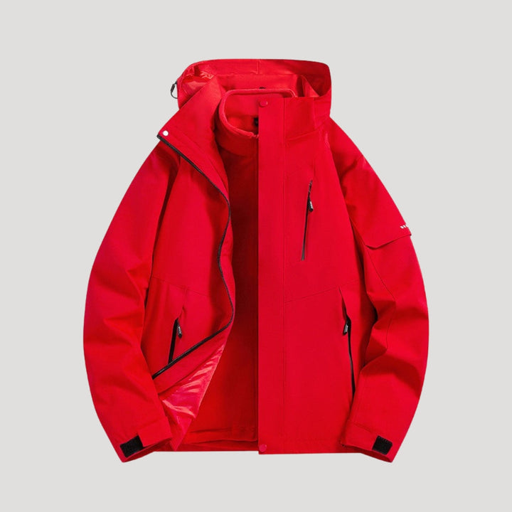 Bright red waterproof women's windbreaker jacket with a functional hood, zip pockets, and adjustable cuffs on a grey background.