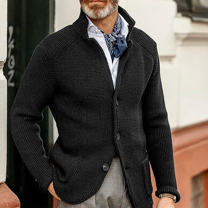 Black textured knit cardigan with a structured standing collar, button-through front, and raglan sleeves.