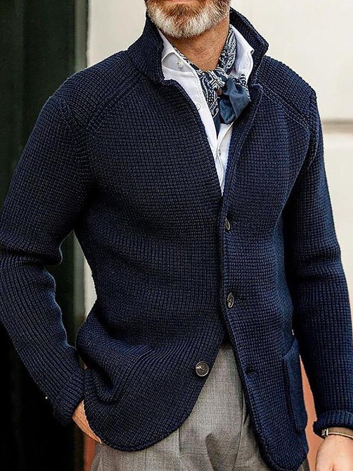 Navy blue textured knit cardigan featuring a structured standing collar, button-through front, and raglan sleeves.