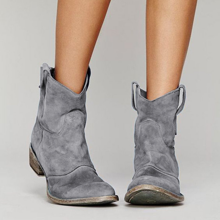 Grey suede-look western ankle boots featuring a low block heel and convenient pull tabs for effortless style.
