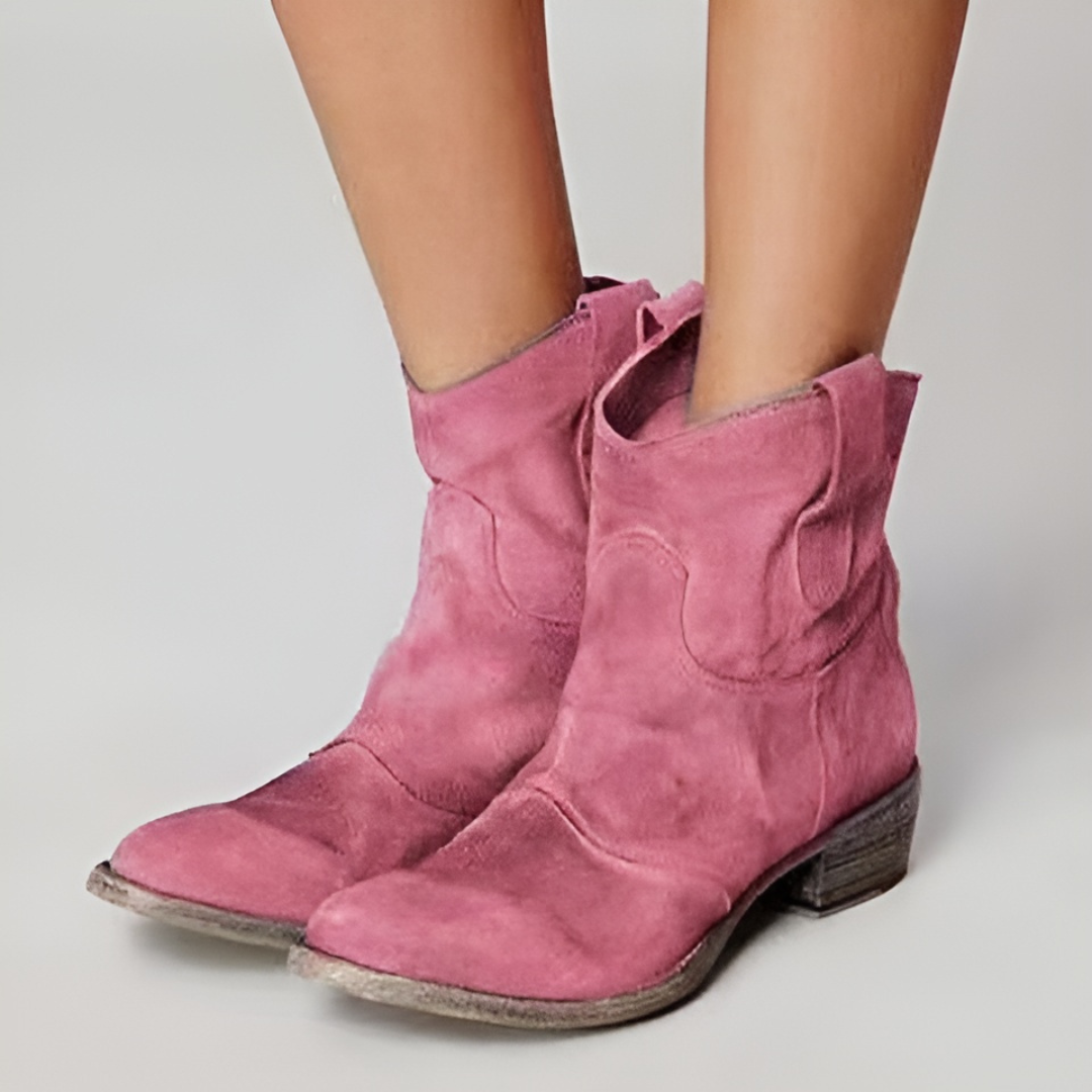 Pink suede-look western ankle boots with a low block heel and convenient pull tabs for a relaxed, stylish fit.