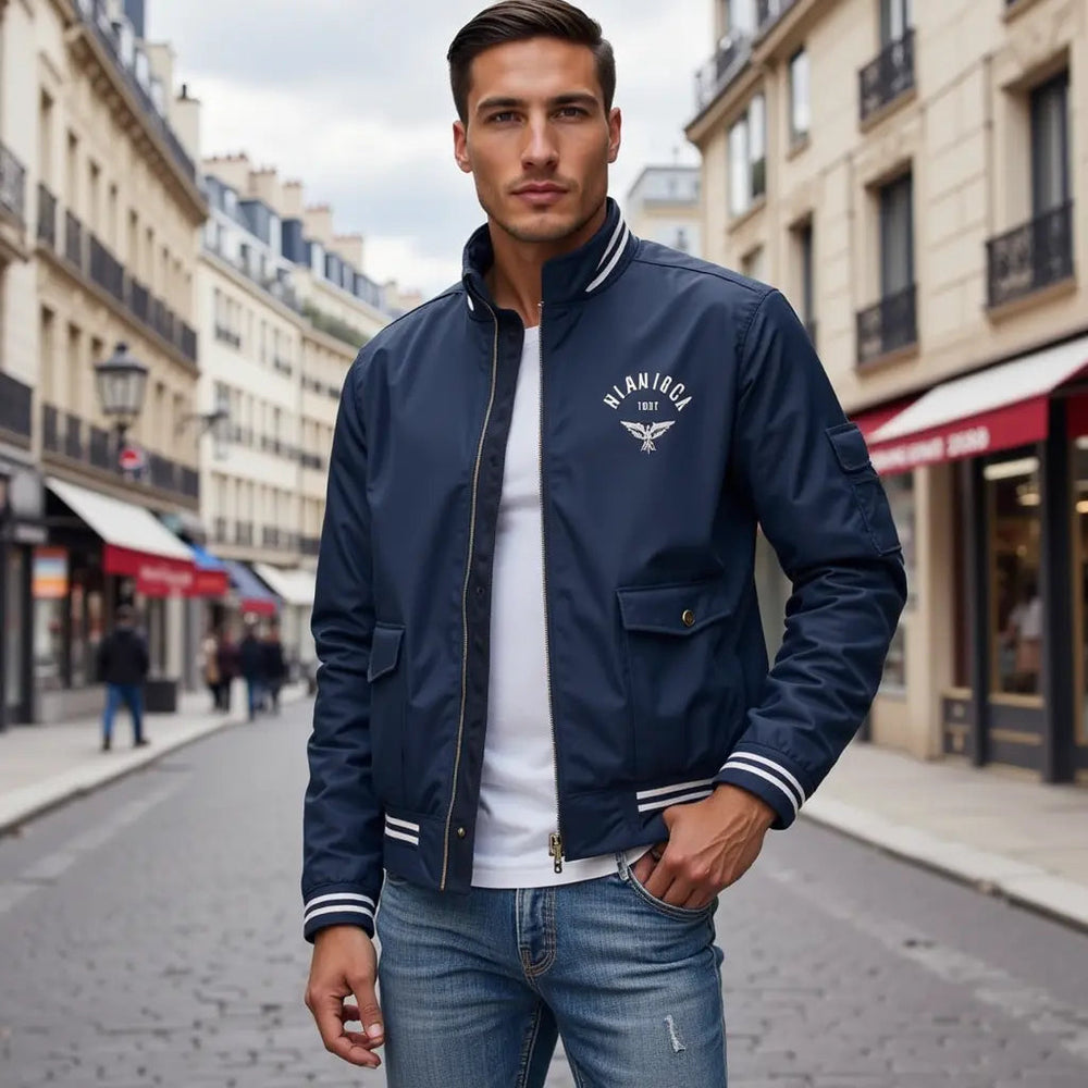 Navy blue zip-up bomber jacket with a stand collar, white striped trim, and chest logo, worn over a white t-shirt.