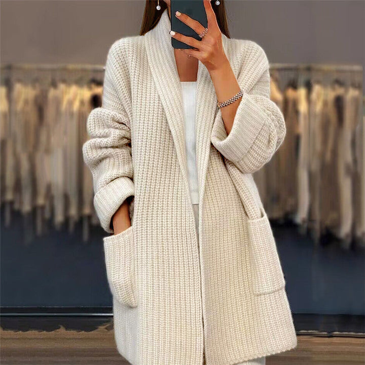 Cream longline chunky knit cardigan with an open front, shawl collar, and two convenient front pockets.
