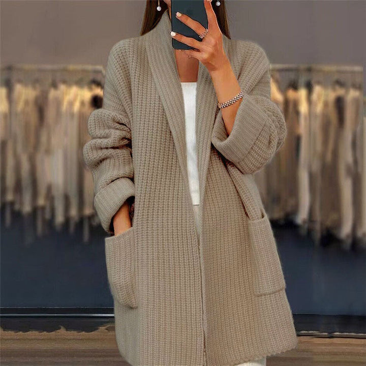 Soft beige longline knit cardigan featuring a relaxed open front, chunky texture, and two convenient front pockets.