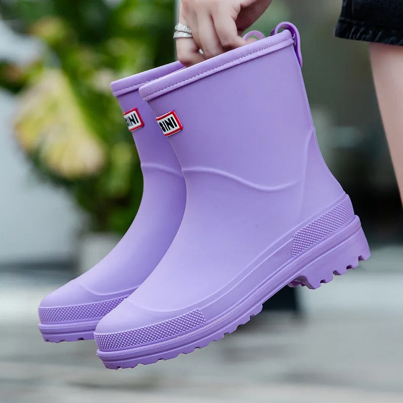 Lavender mid-calf waterproof rain boots with a smooth finish, grippy treaded soles, and a convenient back pull tab.