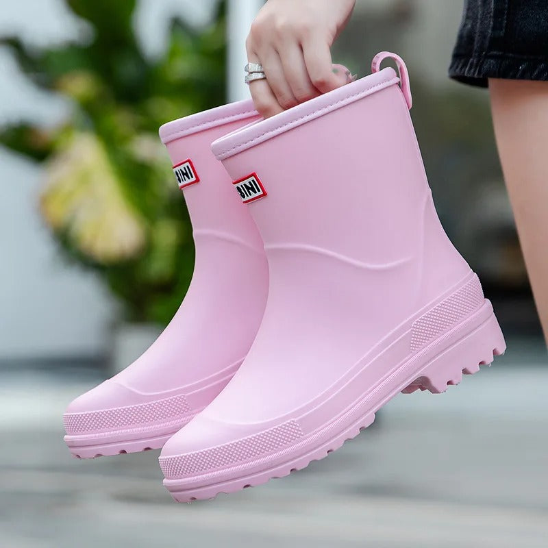Light pink mid-calf waterproof rain boots with a grippy treaded sole and a convenient back pull tab.