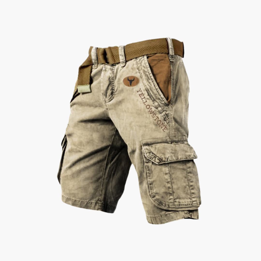 Tan knee-length cargo shorts with side flap pockets, Yellowstone branding, and a brown canvas belt.