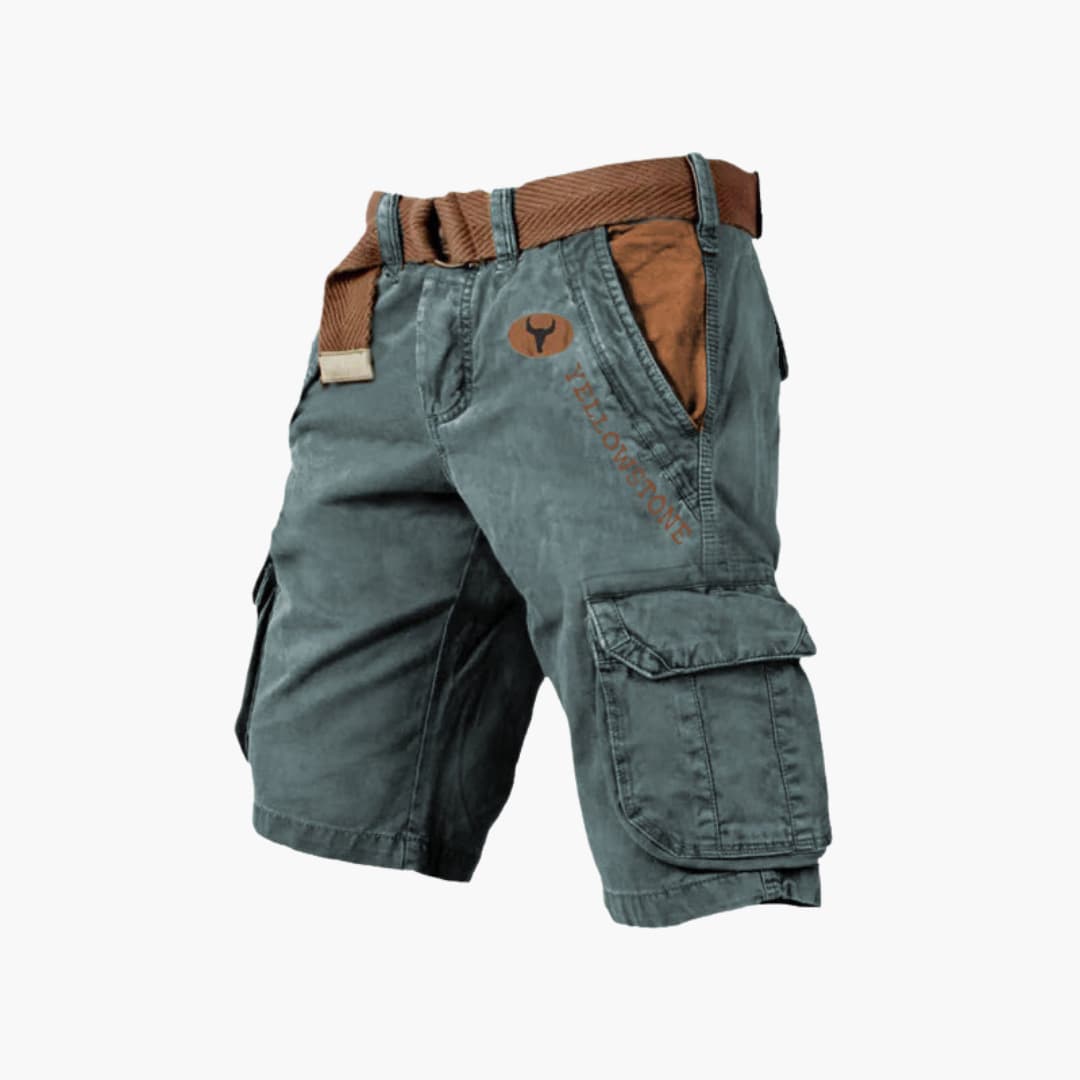 Dark green knee-length cargo shorts with brown belt, side flap pockets, and Yellowstone branding on a white background.