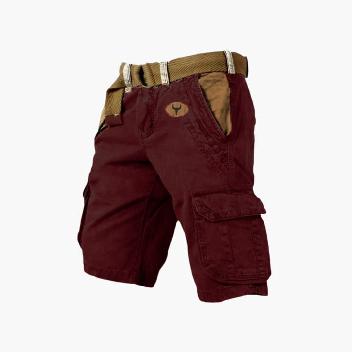 Burgundy knee-length cargo shorts with side flap pockets, a tan belt, and Yellowstone branding on the front.