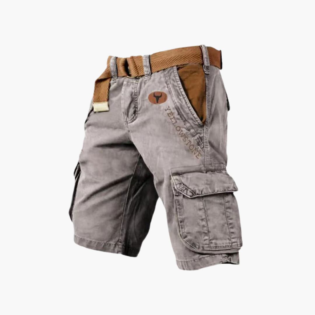 Grey knee-length cargo shorts with side flap pockets, brown belt, and Yellowstone branding on a rugged cotton fabric.