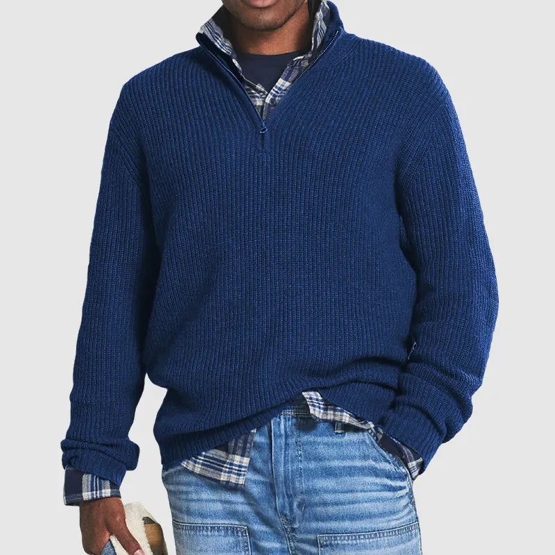 Men’s navy blue ribbed knit quarter-zip jumper with a funnel collar, layered over a plaid shirt and blue jeans.