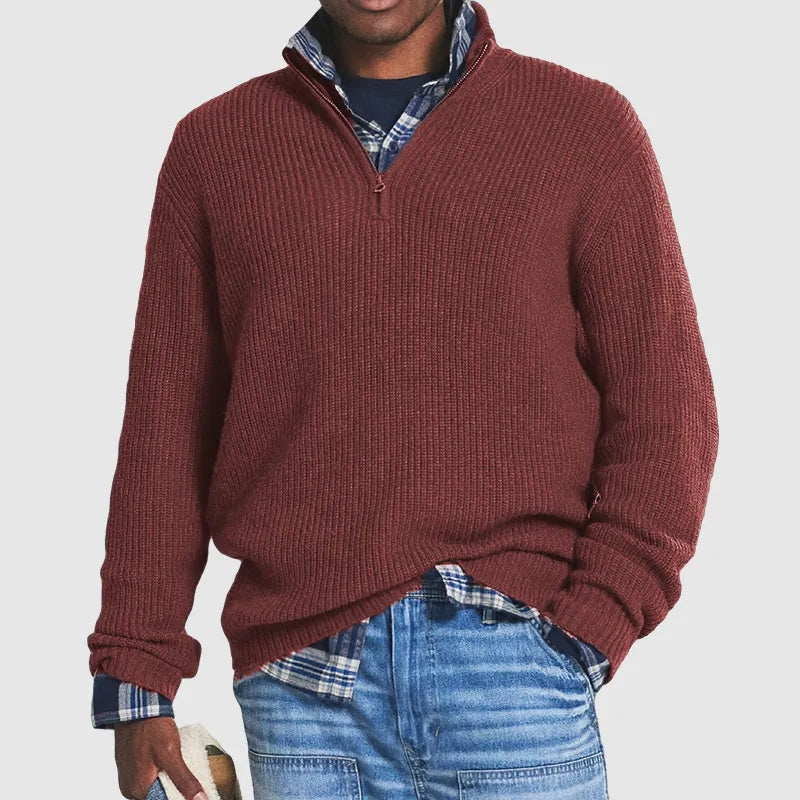 Burgundy ribbed knit quarter-zip jumper with a funnel collar, layered over a plaid shirt and blue jeans.