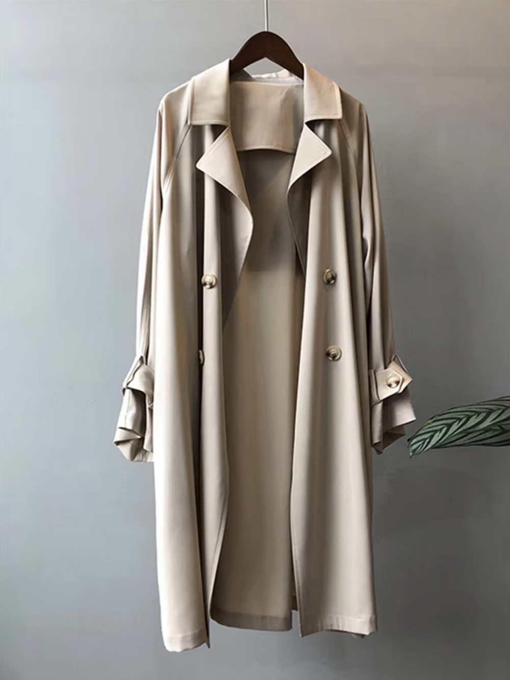 Beige waterproof double-breasted trench coat with a sharp notch lapel and elegant buttoned sleeve tabs.