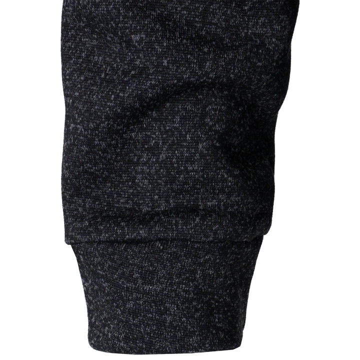 Close-up of a black marled knit sweater sleeve with a ribbed cuff, showcasing the soft, textured fabric detail.