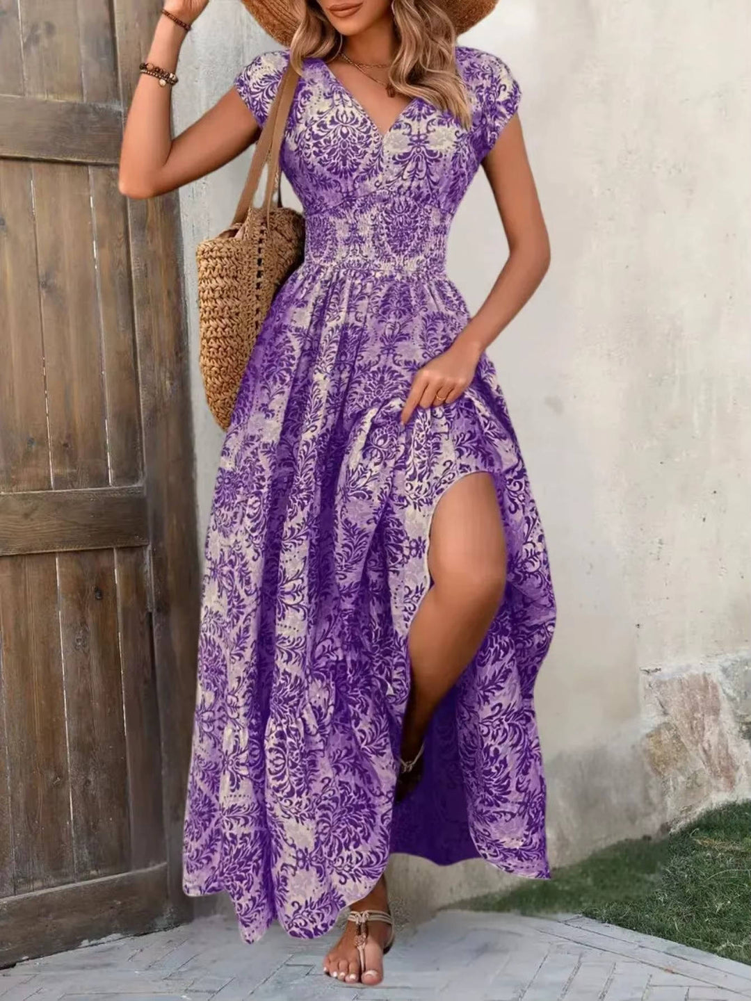 Purple floral boho maxi dress with a V-neck, smocked bodice, cap sleeves, and a tiered skirt with a high leg slit.
