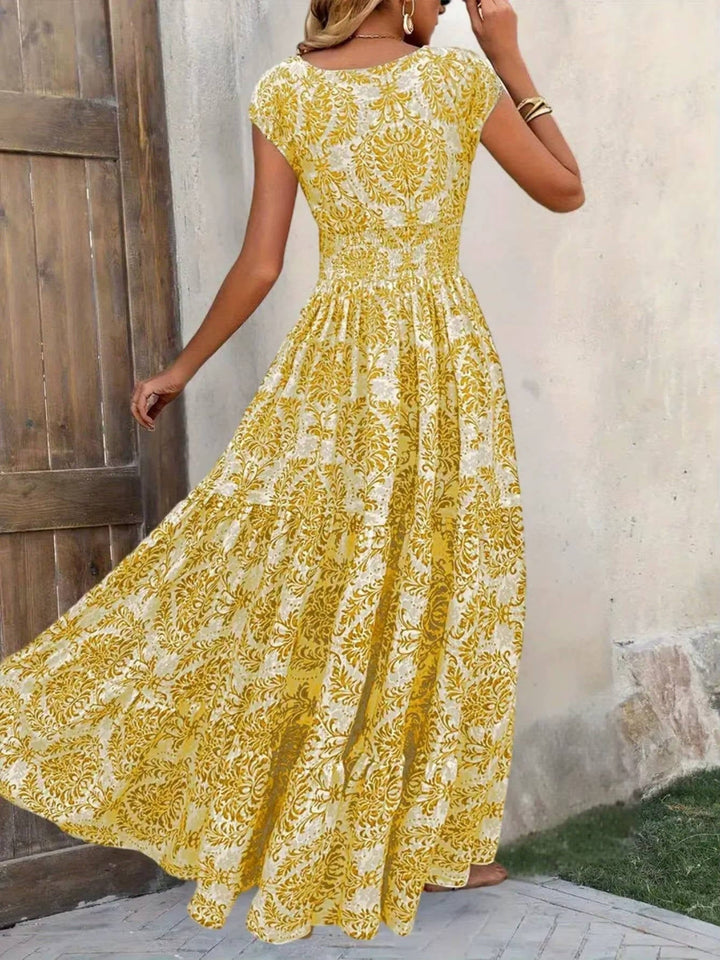 Yellow floral boho maxi dress with a smocked bodice, cap sleeves, and a tiered, flowing skirt.