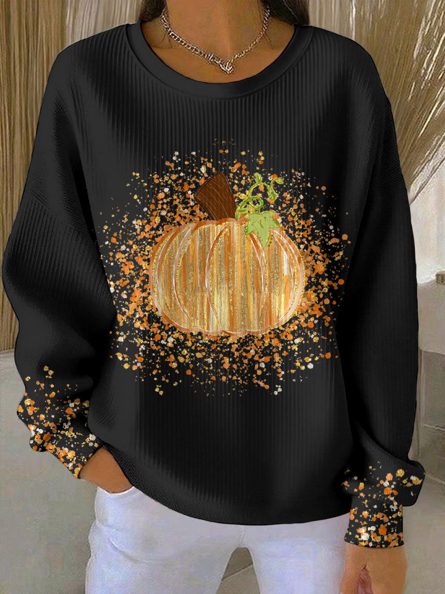 Black ribbed crew neck sweatshirt featuring a glittery pumpkin graphic and orange paint splatter details on the sleeves.