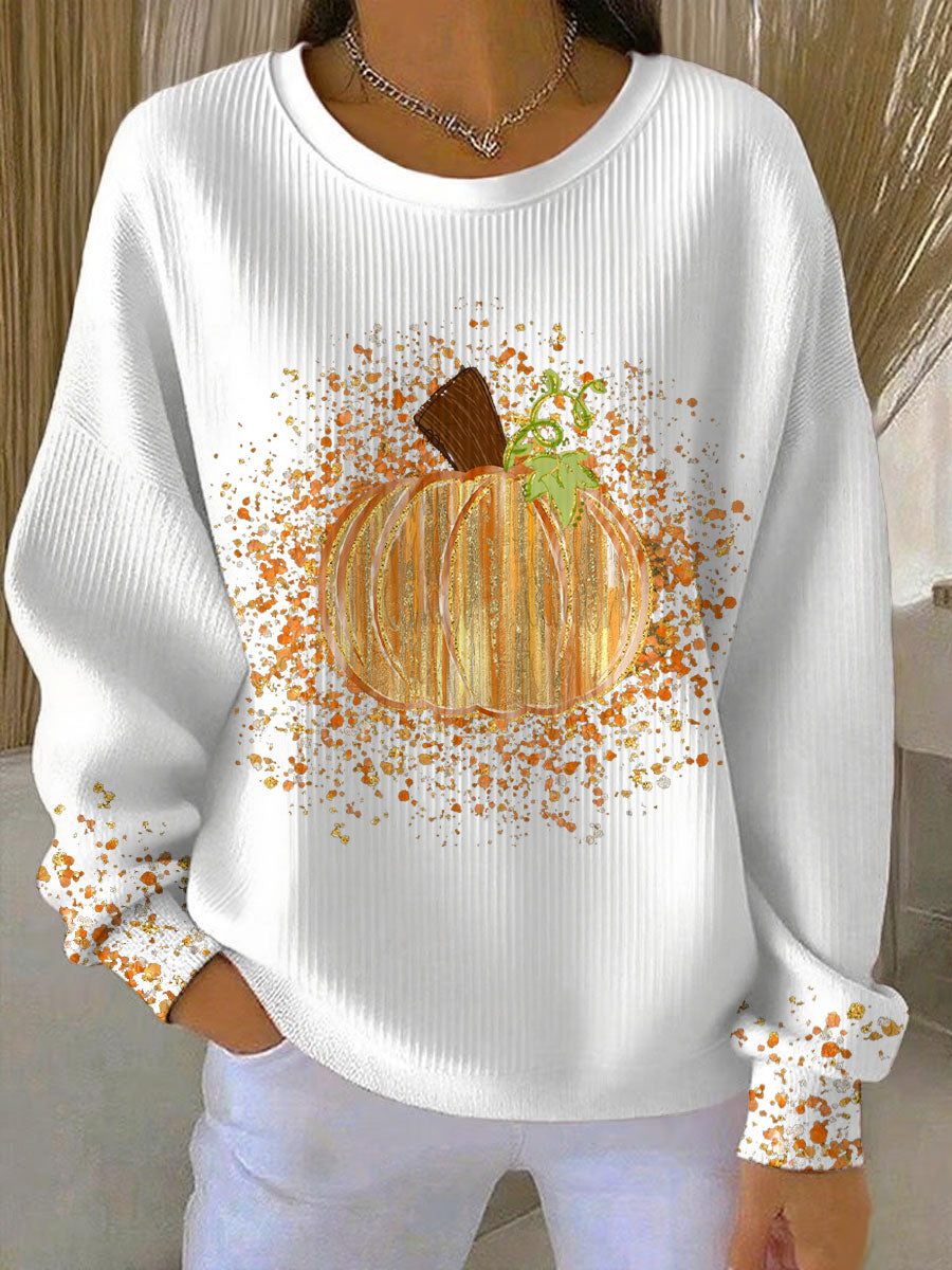 White ribbed crew neck sweatshirt featuring a glittery orange pumpkin graphic and autumn-themed paint splatter details.