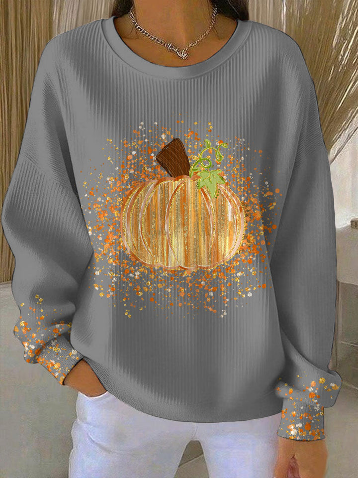 Grey ribbed crew neck sweatshirt featuring a glittery orange pumpkin graphic and festive paint-splatter sleeve details.